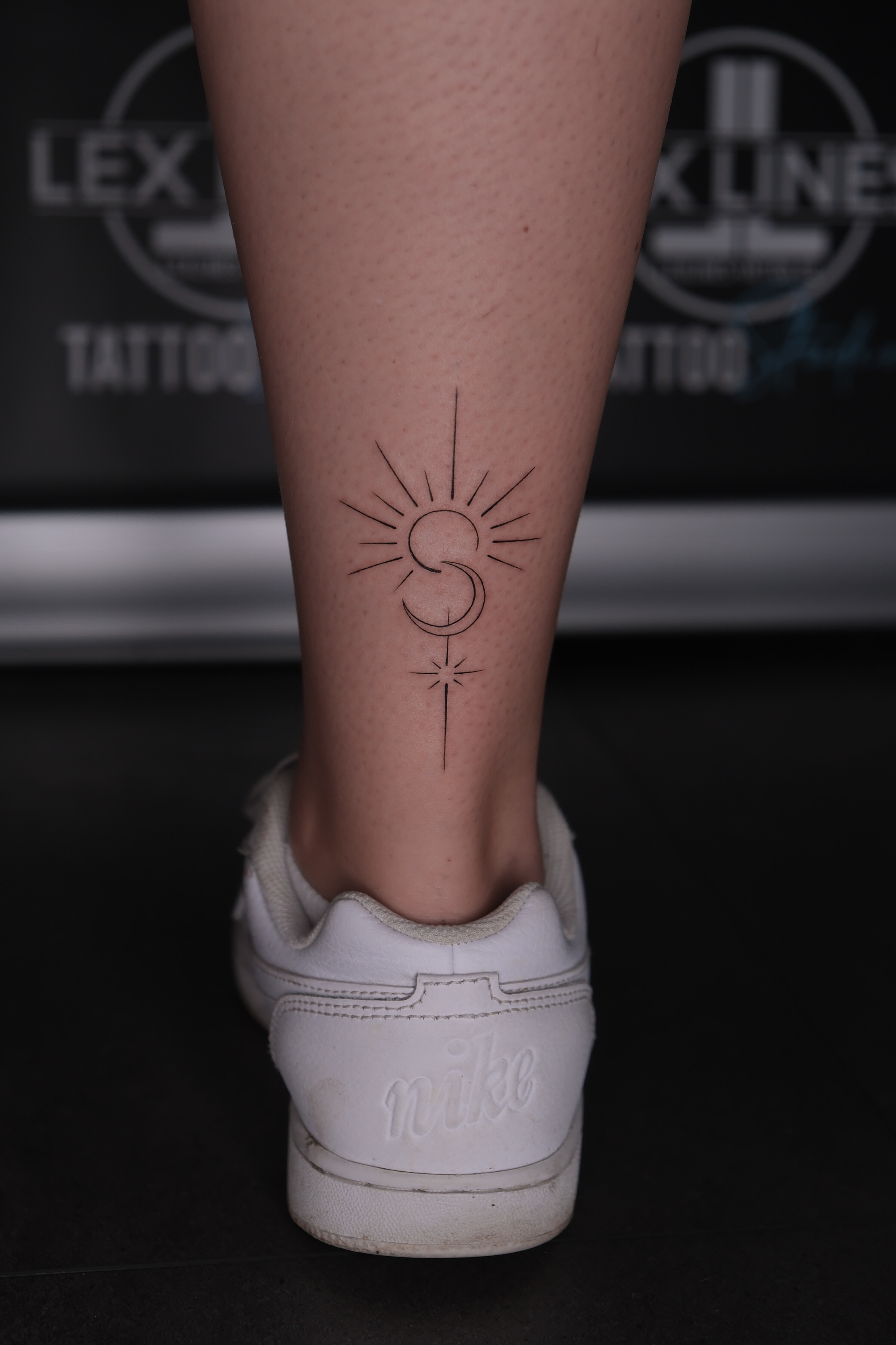 Feines Sonnen- und Mondtattoo am Knöchel